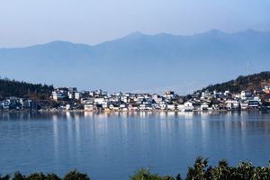a town on a lake with mountains in the background
