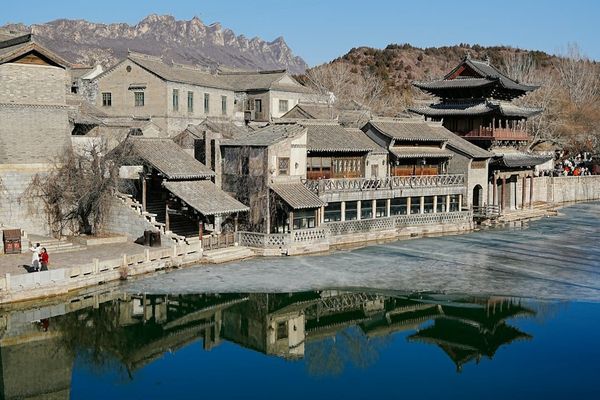 Historic buildings line a river with reflections in Chaoshan