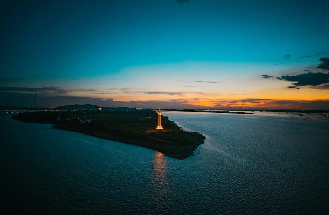 Lighthouse on an island at dusk with colorful sky