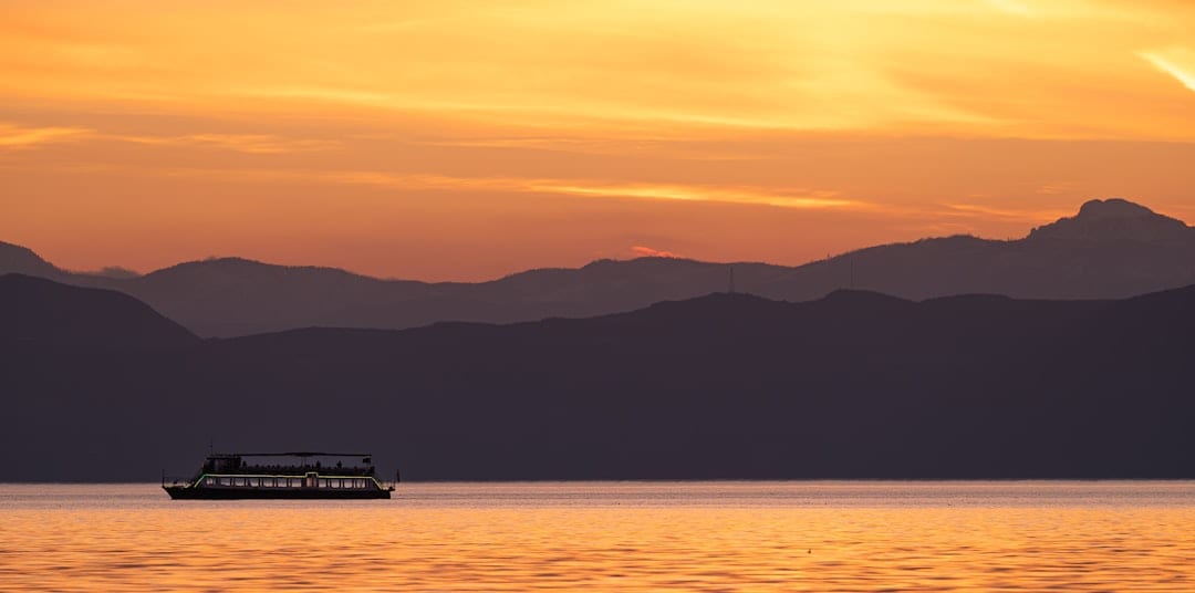 Yangtze River cruise ship sailing at sunset with mountain backdrop
