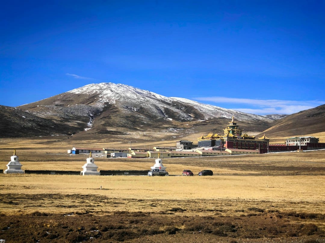 Ganden Monastery set against grassland and snowy peaks