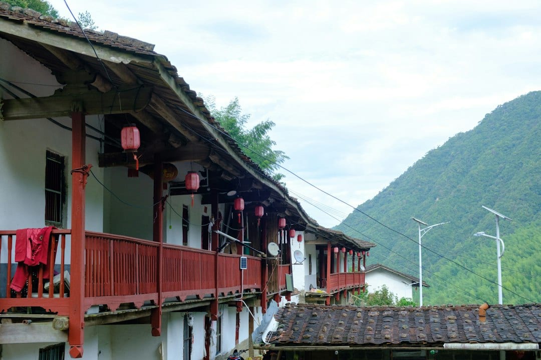Traditional Chinese coastal village with red lanterns and mountains