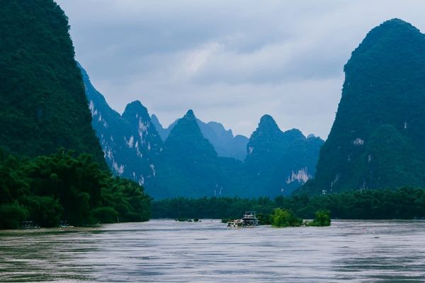 A boat on the Li River with karst mountains in the background