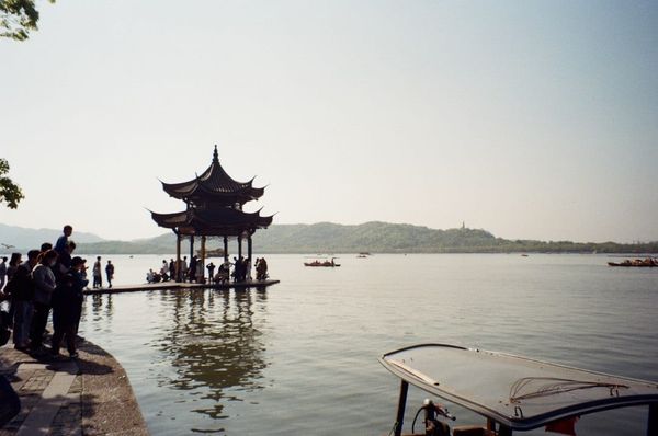 People on a dock by the scenic West Lake in Hangzhou