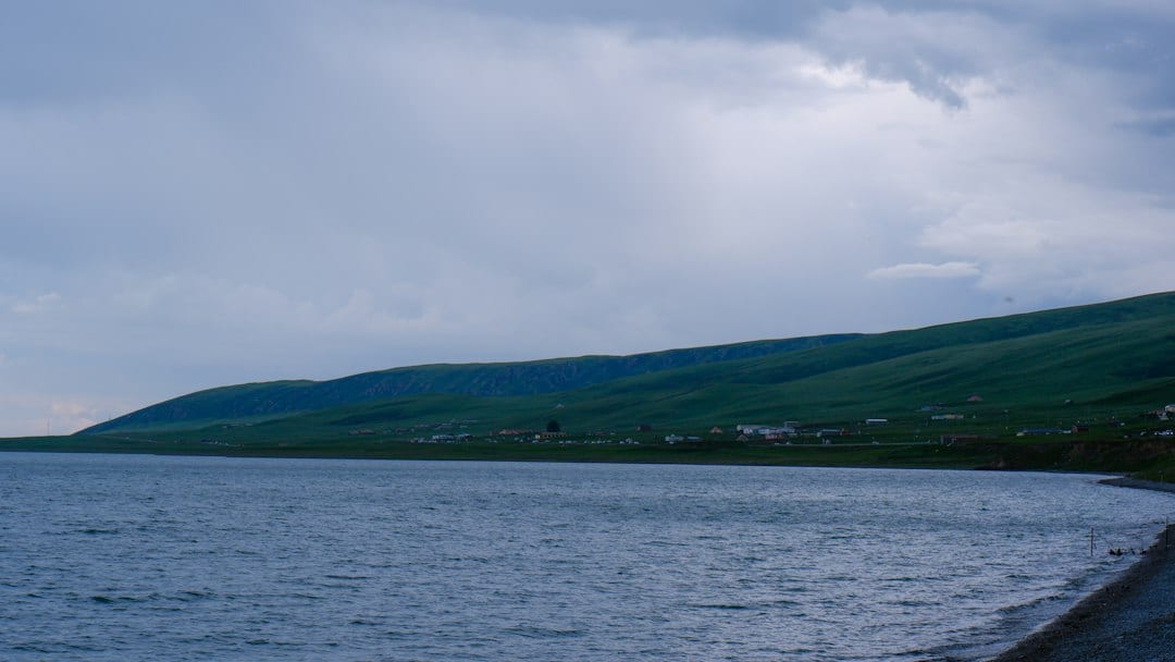 Qinghai Lake scenic landscape with calm blue water and rolling green hills