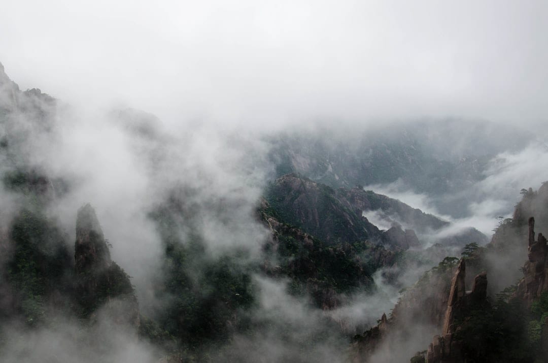 Misty Qinling mountain peaks with lush green forests